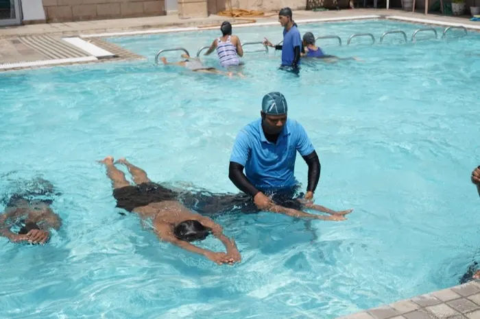 Swim instructor supporting a child through a stroke in a pool