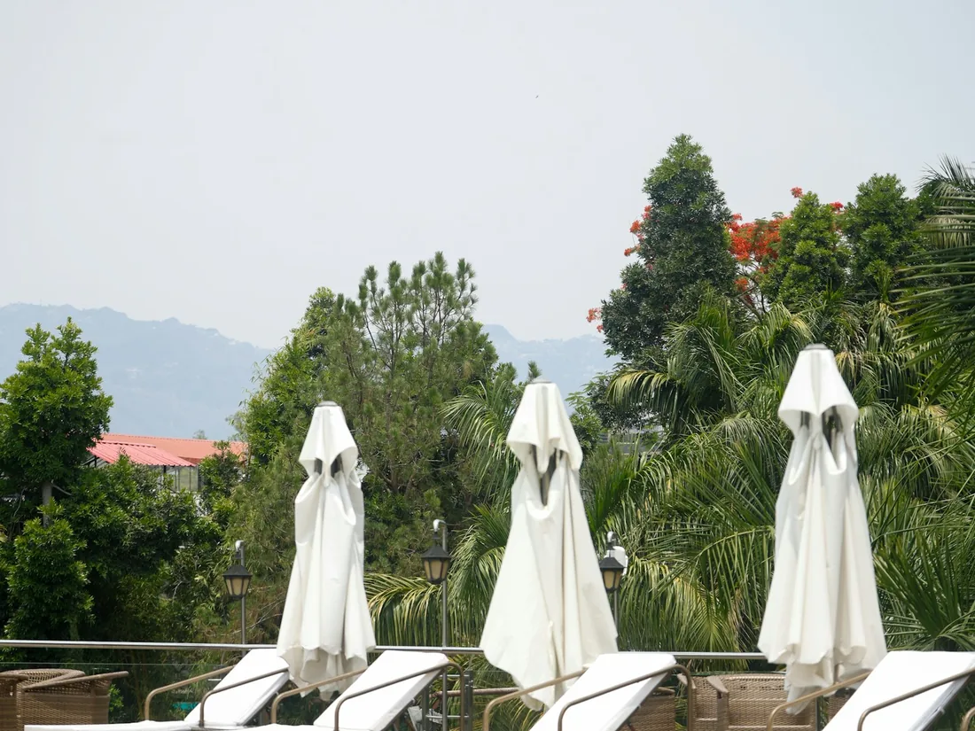 Resort pool deck with lounge chairs and white umbrellas